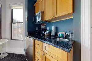 - une cuisine avec un évier et un mur bleu dans l'établissement Cozy Downtown Boston Studio, #45, à Boston