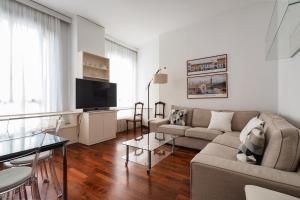 un salon avec un canapé et une télévision dans l'établissement Duomo Luxury Apartment VI, à Milan
