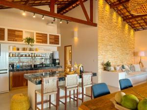 cocina abierta y sala de estar con mesa y sillas en Casa ADOBE Preá - FRENTE MAR! en Prea
