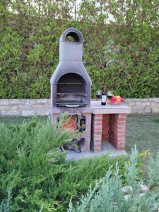 a brick oven sitting in a yard with a table at Private Villa First line with sea view in BlackSeaRama Golf in Balchik