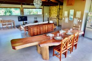 a dining room with a wooden table and chairs at HaraMatha in Barra Grande