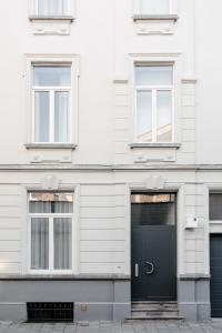 um edifício branco com uma porta preta e janelas em Edgar Guesthouse em Gent