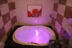 Motel Desejo في بورتو أليغري: حمام مع حوض كبير مع إضاءة أرجوانية
