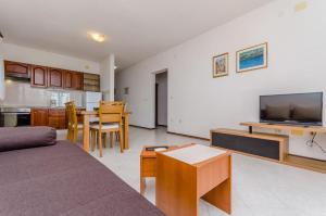 - un salon avec un canapé, une télévision et une table dans l'établissement Apartments Jurko, à Trogir