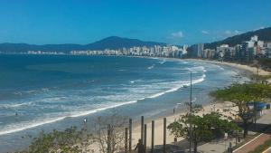 vista su una spiaggia con una città sullo sfondo di Apartamento de Cobertura frente para o mar Itapema a Itapema