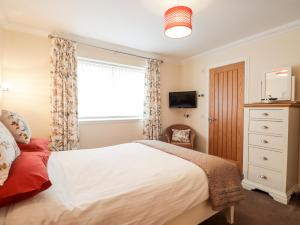a bedroom with a large bed and a window at Riverside Cottage in Portree