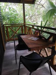 a wooden table and chairs on a porch at Casa el Colibrí in Parrita