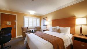a hotel room with two beds and a desk at SFO Airport Hotel, El Rancho Inn Signature Collection in Millbrae