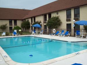 una piscina frente a un edificio con sillas y sombrillas en Best Western Galaxy Inn, en Dover