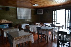 a dining room with tables and chairs with white table cloth at Pousada Do Farol in Capão da Canoa