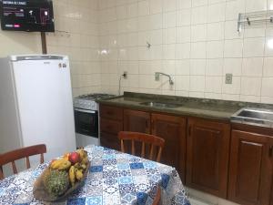 a kitchen with a table with a bowl of fruit on it at Regina Del Mare Residence Apartamentos completos para até 05 pessoas a 50 metros da praia in Florianópolis +69 photos