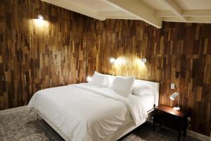 a bedroom with a white bed and a wooden wall at Casa Modi in Puerto Viejo +80 photos