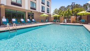 a swimming pool at a hotel with chairs and umbrellas at Best Western Plus Birmingham Inn & Suites in Birmingham