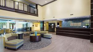 a lobby with a waiting area with chairs and a counter at Best Western Plus Birmingham Inn & Suites in Birmingham