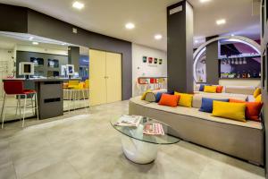 un soggiorno con divano e cuscini colorati di La Villa - Sure Hotel Collection by Best Western a Ivrea