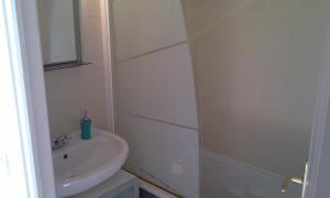une salle de bain blanche avec un lavabo et une douche dans l'établissement Le Duplex, à Honfleur 25 autres photos