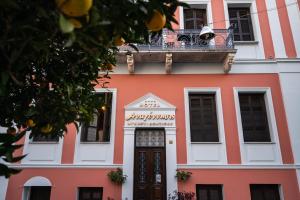 an orange and white building with a balcony at Boutique Hotel Anagennisis in Pýrgos