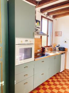 a kitchen with white cabinets and a stove top oven at L’Alcalys - Maison de vacances au vert - Sans TV in Saint-Aignan