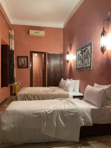 two beds in a room with pink walls at Riad Safia in Marrakesh +72 photos