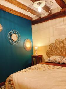- une chambre avec un lit et un mur bleu dans l'établissement L’Alcalys - Maison de vacances au vert - Sans TV, à Saint-Aignan