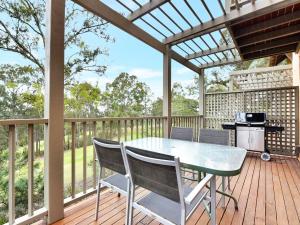a patio with a table and chairs on a deck at Villa 2br Prosecco Villa located within Cypress Lakes Resort in Pokolbin