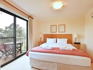 una camera da letto con un letto grande e un balcone di Villa 2br Prosecco Villa located within Cypress Lakes Resort a Pokolbin