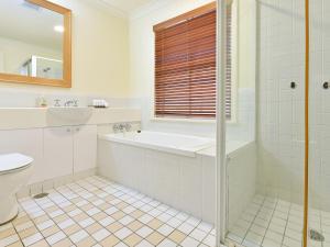 ein Badezimmer mit einer Badewanne, einem Waschbecken und einem WC in der Unterkunft Villa 2br Prosecco Villa located within Cypress Lakes Resort in Pokolbin