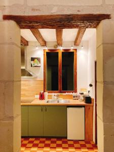 a kitchen with a sink and a window at L’Alcalys - Maison de vacances au vert - Sans TV in Saint-Aignan