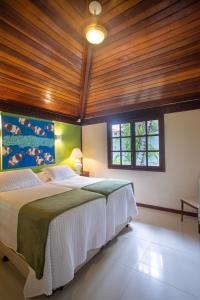 a bedroom with a large bed with a wooden ceiling at Búzios House in Búzios