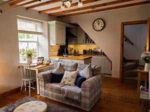 a living room with a couch and a kitchen at Hush Cottage in Middleton in Teesdale
