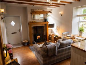 a living room with a couch and a fireplace at Hush Cottage in Middleton in Teesdale
