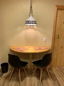 mesa de comedor con sillas y lámpara de araña en Rancho do Xaxim - Gramado, en Gramado