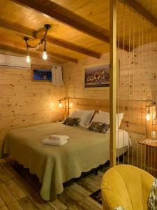 ein Schlafzimmer mit einem Bett in einem Holzzimmer in der Unterkunft Rancho do Xaxim - Gramado in Gramado