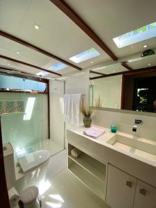 a bathroom with a sink and a toilet and a mirror at Búzios House Oficial in Búzios +83 photos