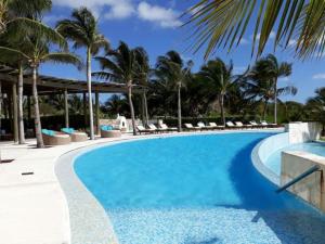 a pool at a resort with palm trees at Ocean front apartment in Cancun in Cancún