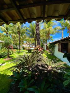a view of a yard with palm trees and a house at Búzios House Oficial in Búzios