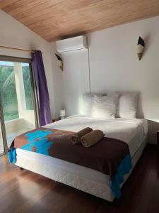 a bedroom with a large bed and a window at Moorea Temae Villa walking dist beach and golf in Moorea