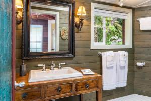 a bathroom with a sink and a mirror and towels at Volcano Village Estates in Volcano