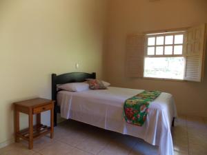 Schlafzimmer mit einem Bett mit einem Tisch und einem Fenster in der Unterkunft Águas Vivas Hotel Fazenda in Pirenópolis