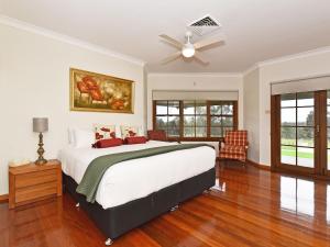 a bedroom with a bed and a ceiling fan at Marrowbone Mountain Views in Pokolbin