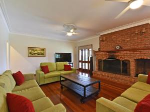 a living room with a couch and a fireplace at Marrowbone Mountain Views in Pokolbin