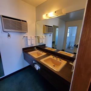 a bathroom with two sinks and a large mirror at Robin Hood Motel in Raton +37 photos