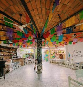 a room with a ceiling covered in colorful flags at La Redonda Sayulita Hostal in Sayulita