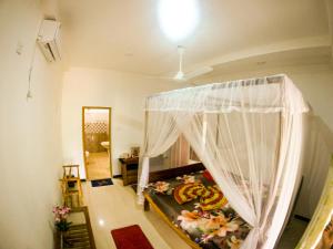 烏納瓦圖納的住宿－Villa Sunimal，一间卧室配有一张带蚊帐的床