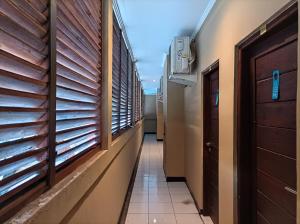 a corridor of a building with windows and a door at Sapta Petala Hotel in Kuta