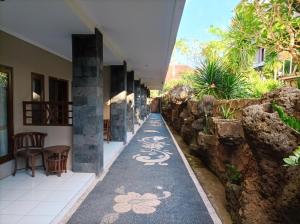 a hallway with a walkway with flowers painted on it at Sapta Petala Hotel in Kuta