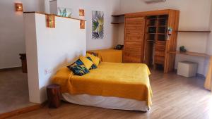a bedroom with a bed with a yellow bedspread at Villa Salamandra in Las Galeras +34 photos