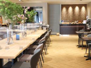 een lange tafel met stoelen en bloemen in een restaurant bij Hotel Abest Grande Takatsuki in Takatsuki