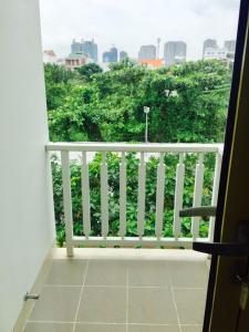Elle comprend un balcon doté d'une balustrade blanche et offrant une vue sur la ville. dans l'établissement Glenwood City Resort, à Hô-Chi-Minh-Ville