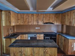 a kitchen with wooden cabinets and a black appliances at Grace - Residential home in Kathmandu